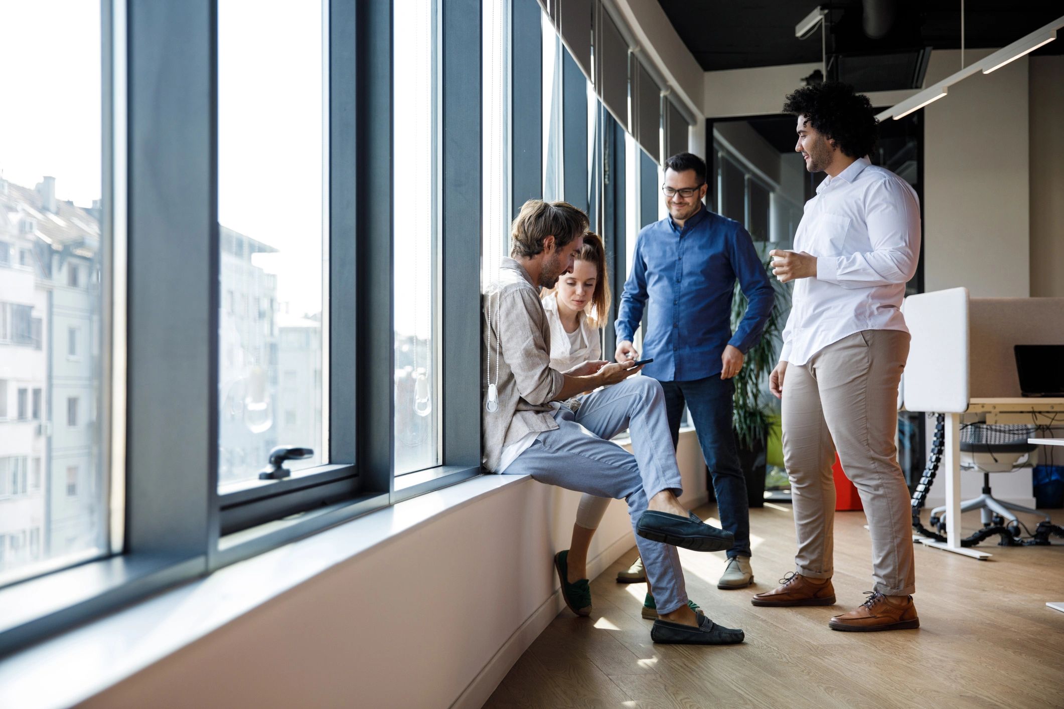 Business colleagues reviewing information together near an office window