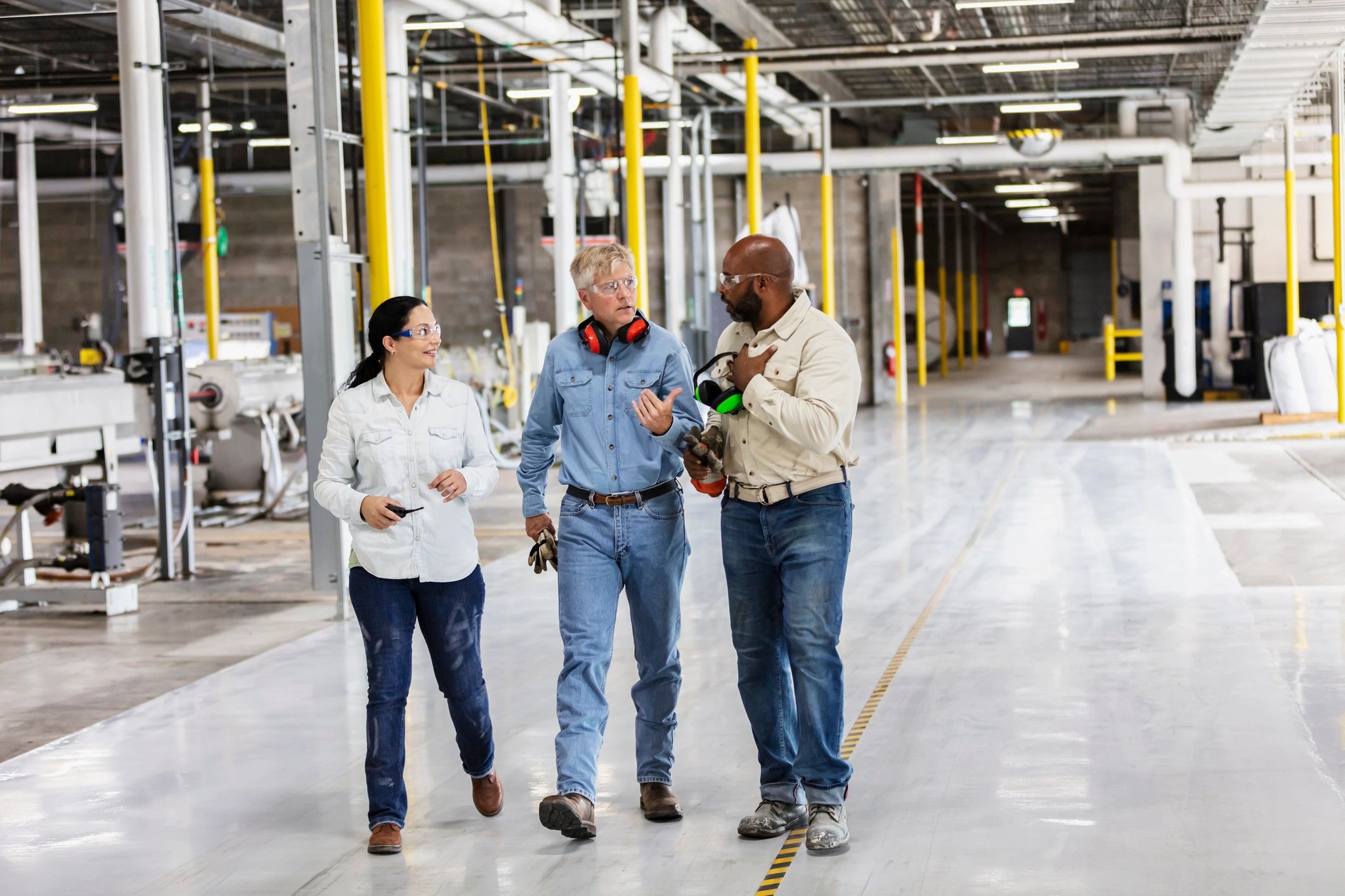 Industrial facility team in proper PPE walking through a plant environment during an operational review
