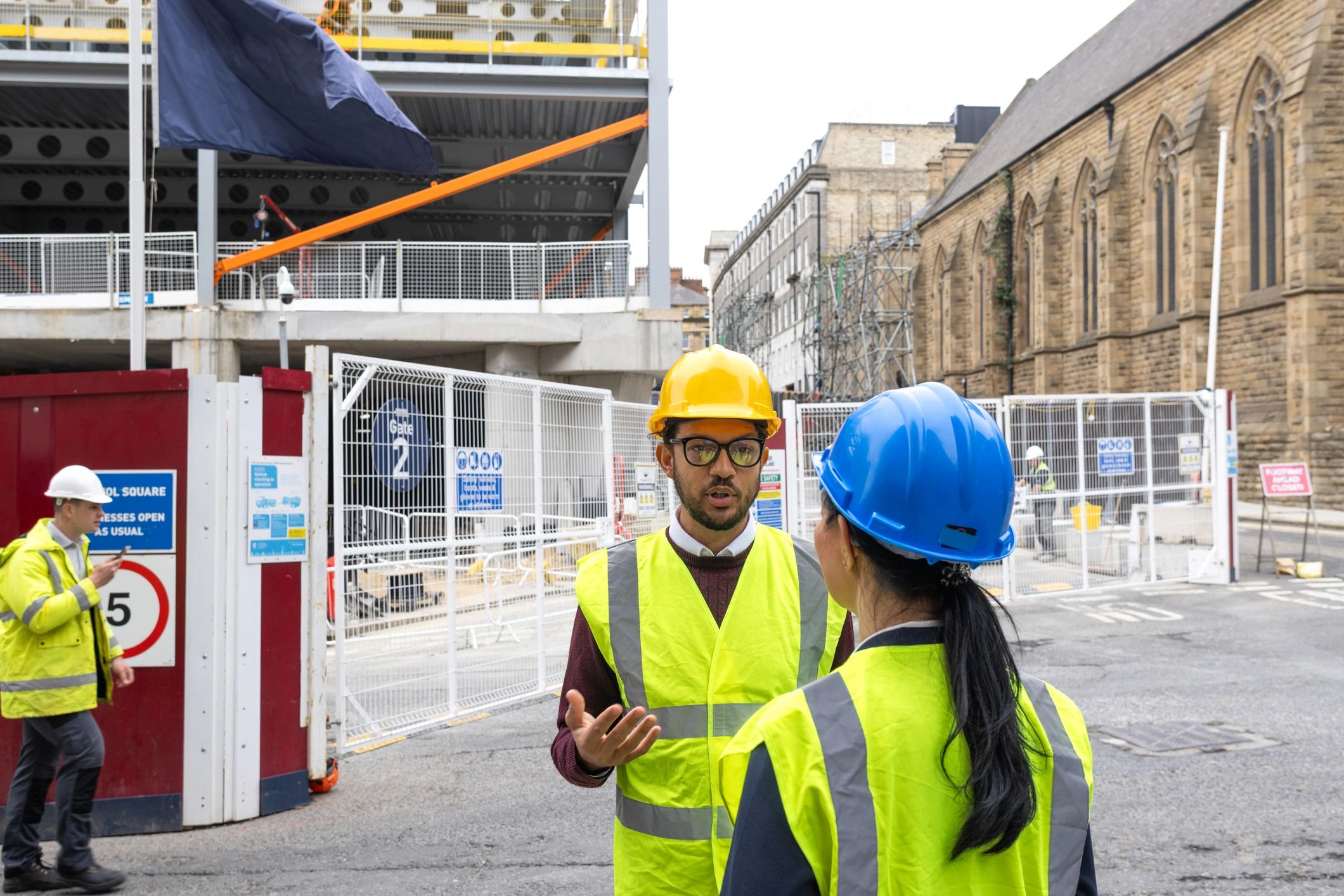 Heavy civil construction team in proper PPE reviewing plans on an active American infrastructure jobsite