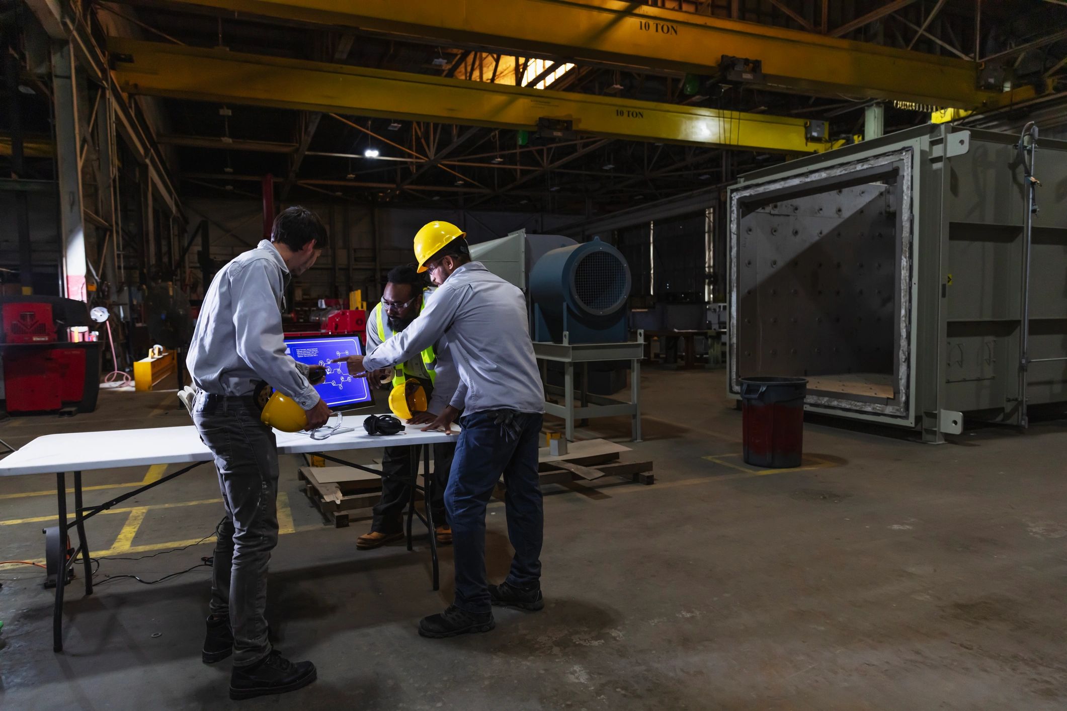 Industrial team reviewing quality and systems information on a factory floor